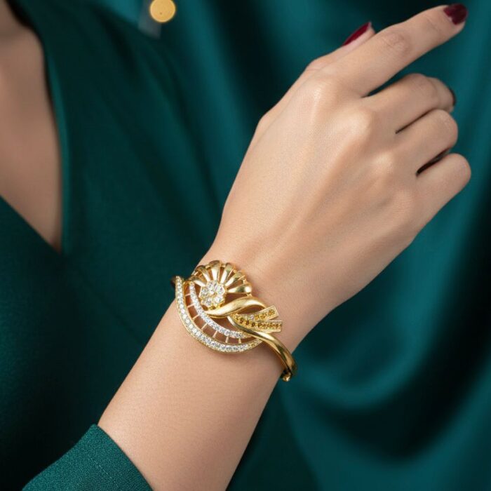 ⁦أسورة ذهبية فاخرة بتصميم زهرة متلألئة، مرصعة بصفين من أحجار الزركون البيضاء. مع قفل جانبي يضفي لمسة فخامة وأناقة لا مثيل لها على معصمك.⁩ - الصورة ⁦2⁩